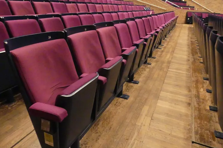 Theater-/Saalbestuhlung, 1 Reihe à 24 Sitzplätze, gepolsterte Klappsitze, pink/schwarz